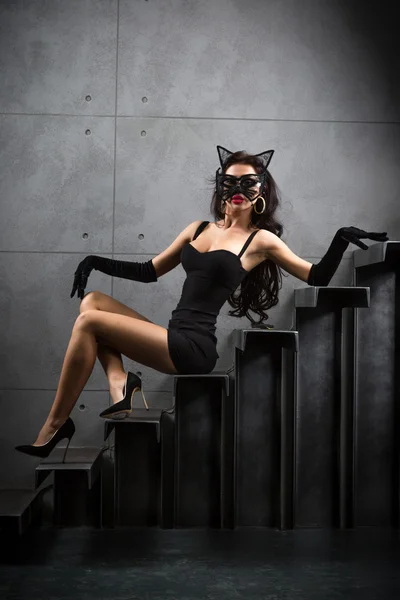 Sexy woman in catwoman suit lying on stairs — Stock Photo, Image