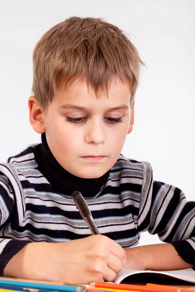 Cute schoolboy is writting — Stock Photo, Image