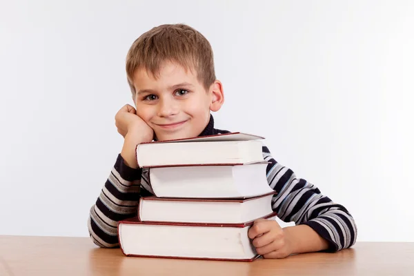 Schooljongen en heap van boeken — Stockfoto