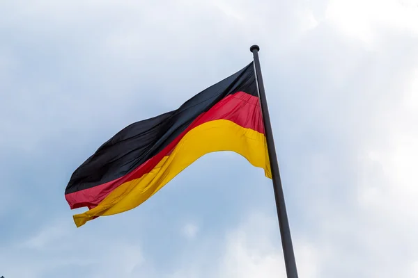 Tyskland flagga framför blå himmel — Stockfoto