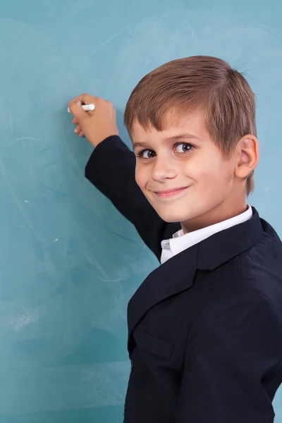 School student writing on blackboard at school — Stock Photo, Image