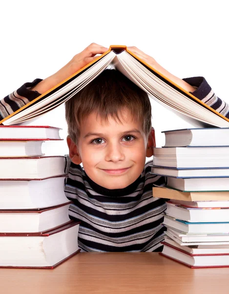 Schoolboy and a heap of books — Stock Photo, Image