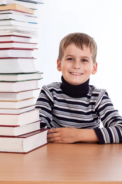 Schooljongen en een hoop van boeken — Stockfoto