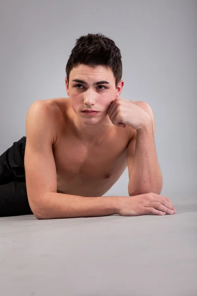 회색 배경에 근육 질의 젊은 남자 — 스톡 사진