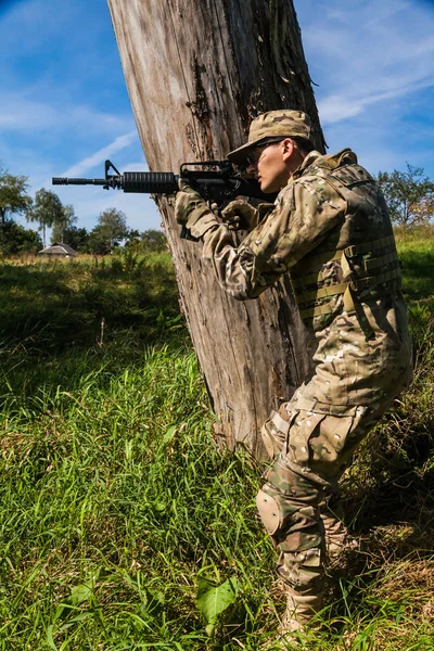 Soldier with rifle in field — Stock Photo, Image