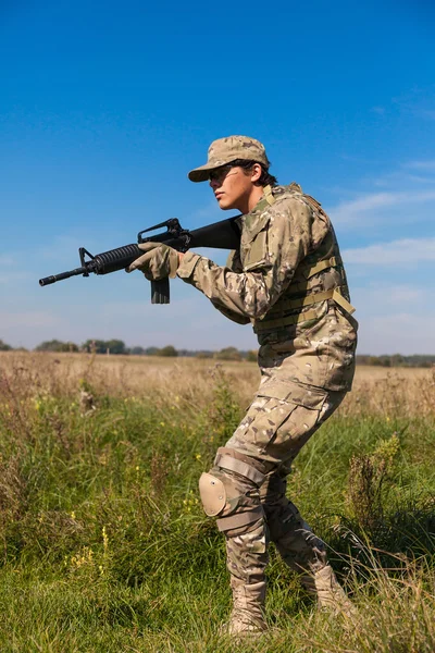 Voják s puškou v poli — Stock fotografie