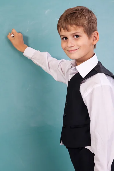 School student writing on blackboard — Stock Photo, Image