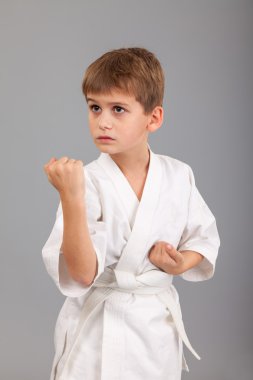Beyaz kimonolu karateci çocuk dövüşüyor.
