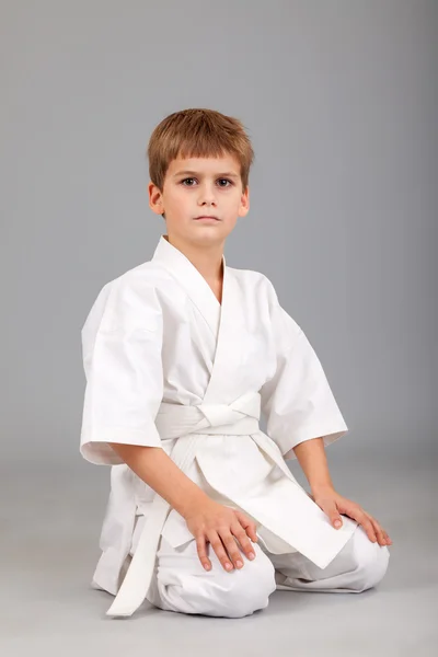 Karate chico en blanco kimono sentado —  Fotos de Stock