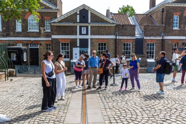 LONDON, İngiltere - 29 Haziran 2024: Londra, İngiltere 'deki Kraliyet Gözlemevi Greenwich avlusunda Birincil Meridyen hattında duran turistler ve ziyaretçiler