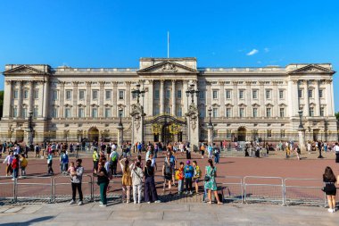 LONDON, İngiltere - 12 AĞUSTOS 2024: Buckingham Sarayı önünde altın kapılar ve mavi gökyüzü ile İngiltere, İngiltere 'de toplanan turistler