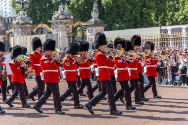 LONDON, İngiltere - 12 AUGust 2024: Güneşli bir günde İngiltere, Londra 'da Buckingham Sarayı' nda Muhafızların Değişimi sırasında kırmızı üniformalı askeri bando yürüyüş