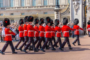 LONDON, İngiltere - 12 AĞUSTOS 2024: Kraliyet Piyade Birliği askerleri Londra, İngiltere 'deki Buckingham Sarayı' nda düzenlenen Muhafız Geçit Töreni sırasında tüfeklerle yürüyen kırmızı üniformalı askerler