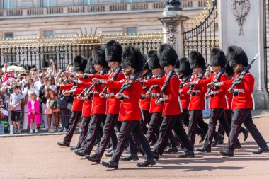 LONDON, İngiltere - 12 AĞUSTOS 2024: Kraliyet Piyade Birliği askerleri Londra, İngiltere 'deki Buckingham Sarayı' nda düzenlenen Muhafız Geçit Töreni sırasında tüfeklerle yürüyen kırmızı üniformalı askerler