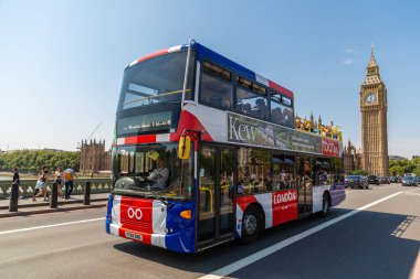 LONDON, İngiltere - 12 AĞUSTOS 2024: Tootbus kırmızı çift katlı, Westminster Köprüsü 'nü Büyük Ben saat kulesi ve İngiltere' de Westminster Sarayı ile geçen tur otobüsü