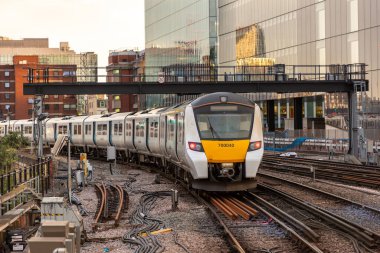 LONDON, İngiltere - 13 AĞUSTOS 2024: British Rail Class 700 Desiro City Thameslink yolcu treni Londra Blackfriars tren istasyonuna gün batımında Londra, İngiltere, Birleşik Krallık 'ta geliyor