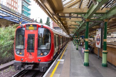 LONDON, İngiltere - 26 AĞUSTOS 2024: Londra Metro treni Güney Kensington İstasyonu 'nda Londra, İngiltere, İngiltere' de bekleyen yolcularla birlikte