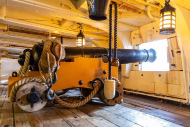 PORTSMOUTH, İngiltere - 22 AĞUSTOS 2024: Birleşik Krallık 'ın Hampshire kentindeki Portsmouth Historic Dockyard' da HMS Victory 'nin tahta top güvertesinde tarihi donanma topu