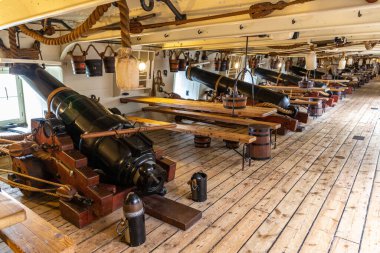 PORTSMOUTH, İngiltere - 22 AĞUSTOS 2024: Portsmouth Historic Dockyard, Hampshire, İngiltere 'de HMS Warrior' da tarihi donanma toplarına sahip silah güvertesi