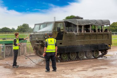 BOVINGTON, İngiltere - 15 Ağustos 2024: Tank Müzesi 'nde bakım ekibi Bovington, Dorset, İngiltere, Birleşik Krallık' ta takip edilen bir M548 kargo aracını yıkıyor