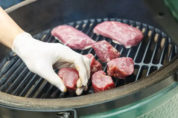 Hombre preparando carne fresca en una parrilla — Foto de Stock