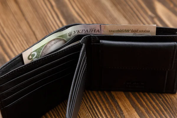 Neue schwarze Ledertasche über dunklem Holzhintergrund. — Stockfoto