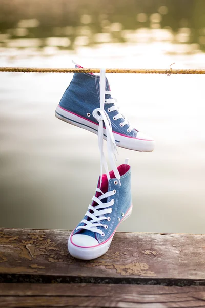 Gebundene Jeans Turnschuhe hängen — Stockfoto