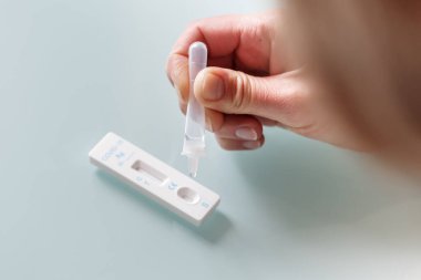 Drop of a test material in a rapid test cassettee  for covid-19 antigen test. Medical care concept