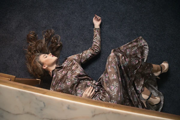 Jonge vrouw in een jurk op de vloer — Stockfoto