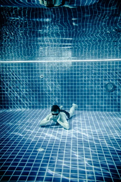 Personas se encuentra bajo el agua en una piscina — Foto de Stock