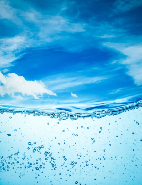 Stäng upp vatten på en bakgrund av blå himmel — Stockfoto