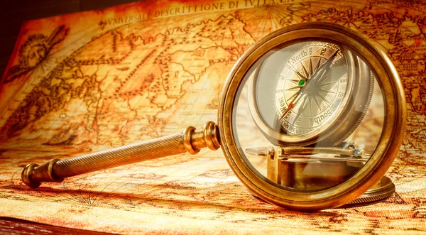 Vintage magnifying glass lies on an ancient world map — Stock Photo, Image