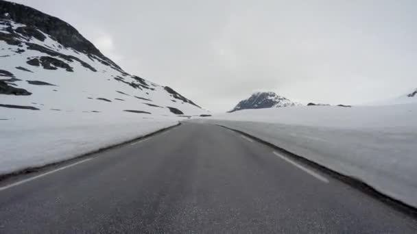 Řízení auta na horské silnici v Norsku s vysokou sněhovou stěnou — Stock video