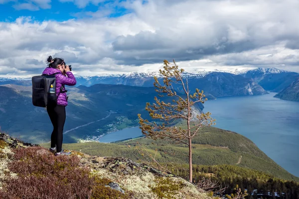 Fotógrafo de natureza turista com tiros de câmera enquanto está em pé no topo da montanha. Bela natureza Noruega. — Fotografia de Stock