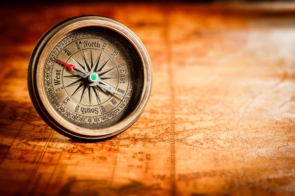 Ročník kompas leží na mapě antického světa. — Stock fotografie
