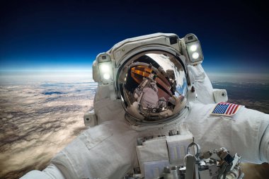 Uzaydaki astronot, Dünya gezegeninin arka planına karşı. Bu görüntünün elementleri NASA tarafından desteklenmektedir.