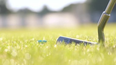 Eldiven takıp golf topuna vuruyor.