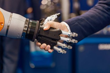 Android bir robotla el sıkışan bir iş adamının eli. Yapay zekayla insan etkileşimi kavramı.