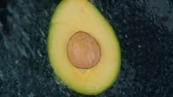 Avocado Mit Klarem Wasserspritzer Auf Schwarzem Hintergrund Super Zeitlupenschleife — Stockvideo