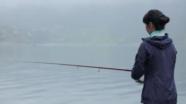 Norveç 'te balık oltasında dönen bir kadın. Norveç 'te balık tutmak yerel yaşam tarzını benimsemenin bir yoludur. Sayısız göl ve nehirler ve geniş bir kıyı şeridi olağanüstü fırsatlar demektir....