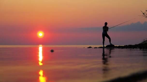 Mulher Pesca Vara Pesca Girando Pôr Sol Fundo — Vídeo de Stock