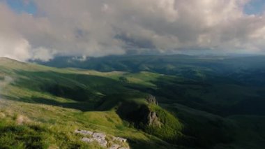 Gün batımında dağlık bir yaylanın üzerinde alçak bulutlar. Bermamyt platosunda gün batımı Kuzey Kafkasya, Karachay-Çerkessia, Rusya.