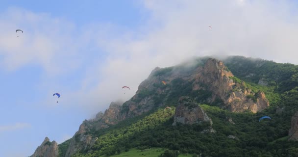 Pilotos Parapente Vuelan Parapentes Entre Nubes Montañas Verdes — Vídeo de stock