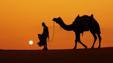 Cameleers, deve sürücüleri gün batımında. Günbatımında çöl Jaisalmer, Rajasthan, Hindistan.