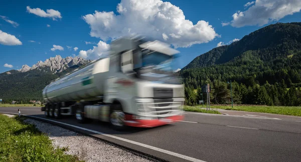 燃料トラックはアルプスを背景に高速道路を駆け下ります トラックの車の動きにぼかし — ストック写真