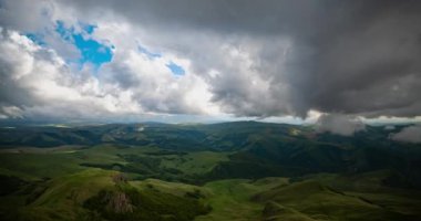 Gün batımında dağlık bir yaylanın üzerinde alçak bulutlar. Bermamyt platosunda gün batımı Kuzey Kafkasya, Karachay-Çerkessia, Rusya.