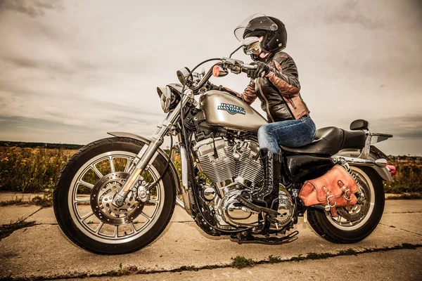 Байкерская девочка и велосипед Harley Sportster — стоковое фото
