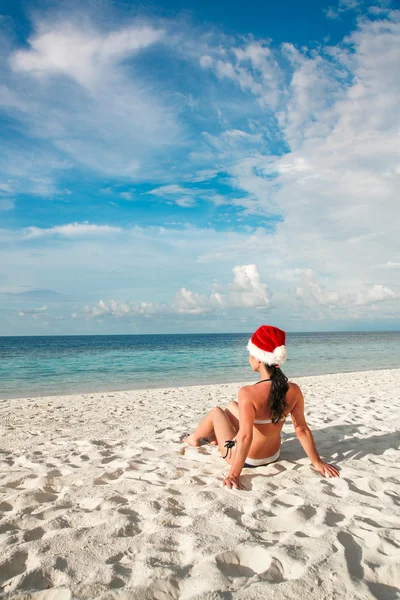 Woman in santa hat on the beach — Stock Photo, Image