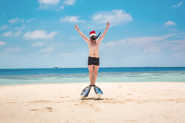 Hombre en sombrero de santa en la playa tropical — Foto de Stock