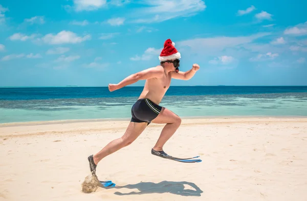 Hombre en sombrero de santa en la playa tropical — Foto de Stock